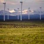 Wind turbines and snowy mountains at a Wyoming wind farm.